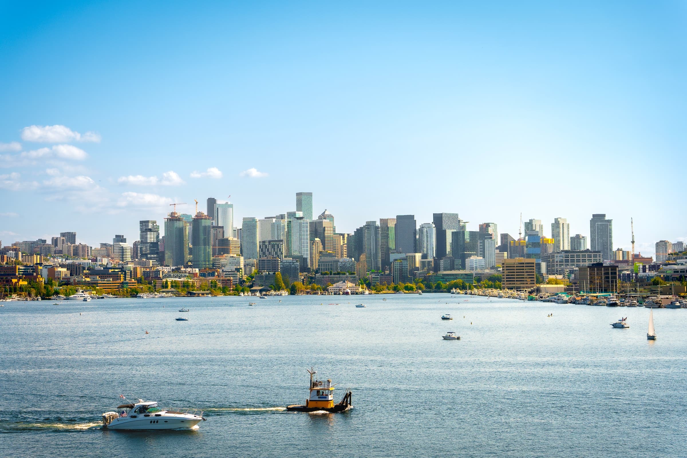 City skyline across water with boats in the foreground