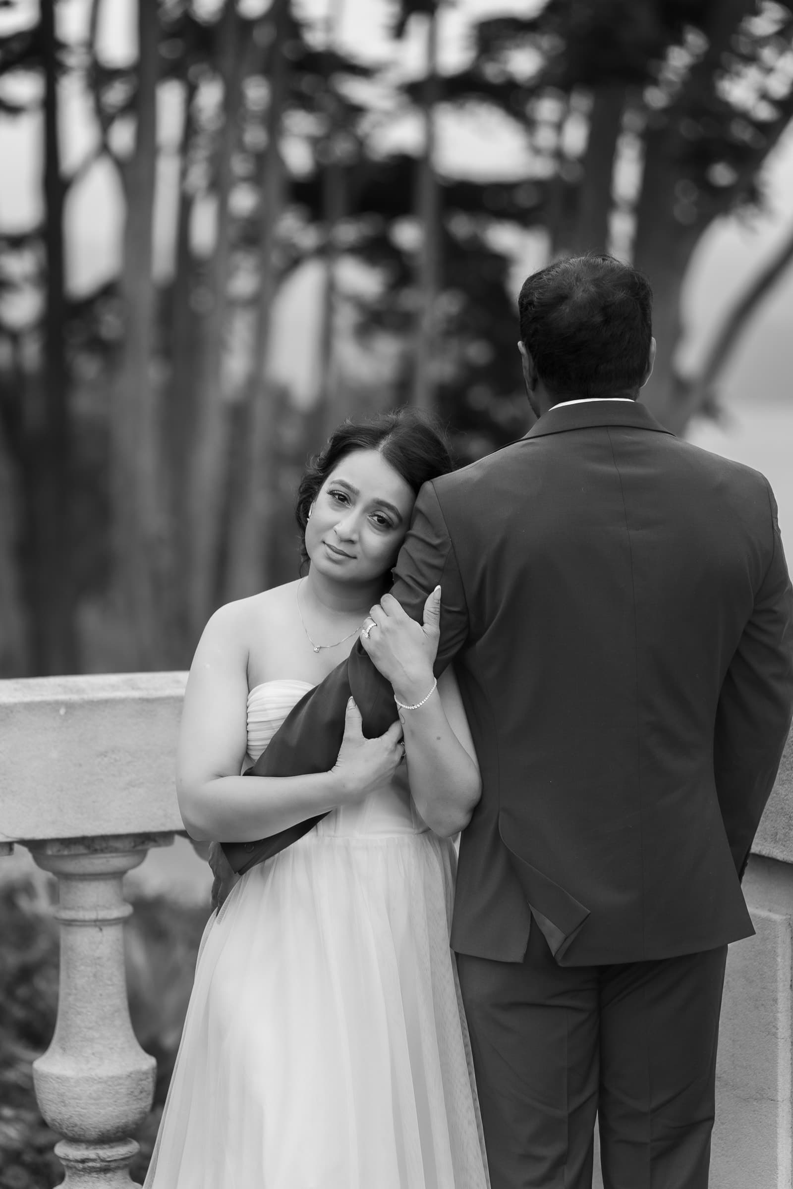Black-and-white portrait of a couple beneath trees