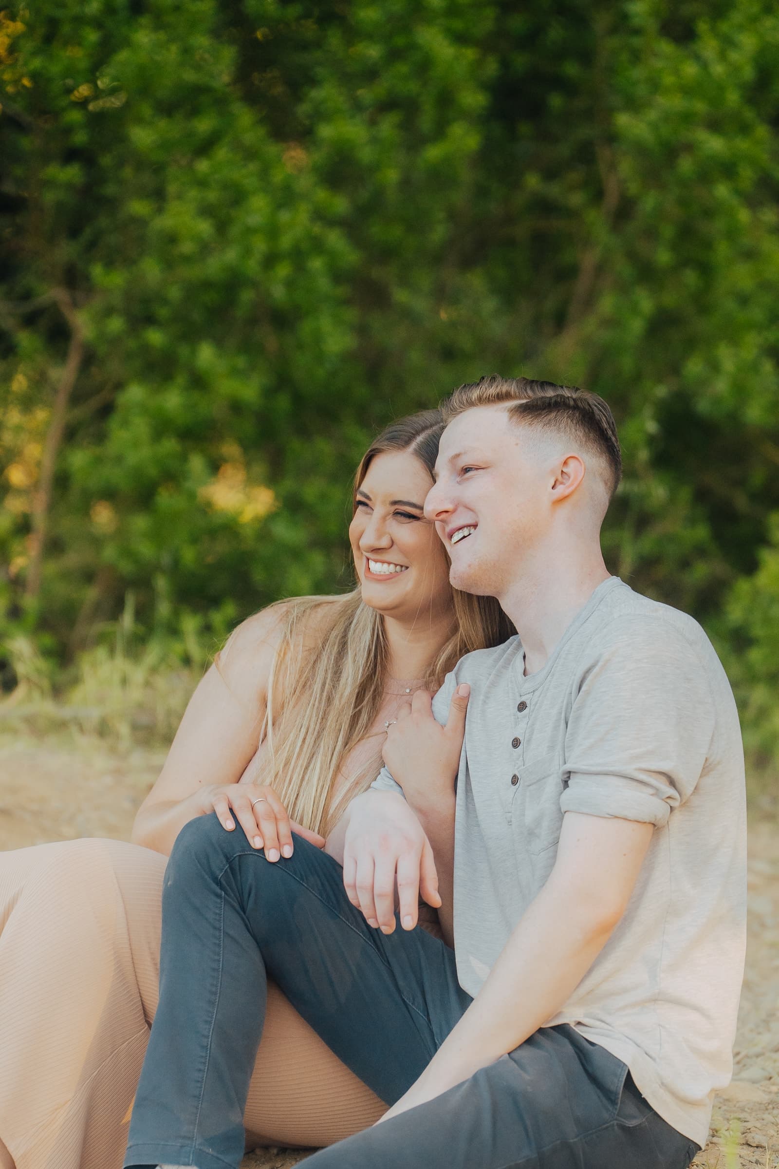 Couple sitting together on a sunlit grassy slope